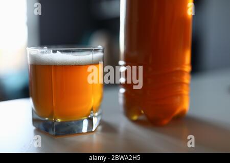 Auf dem Tisch ist eine volle Flasche und ein Glas frisches Bier Stockfoto