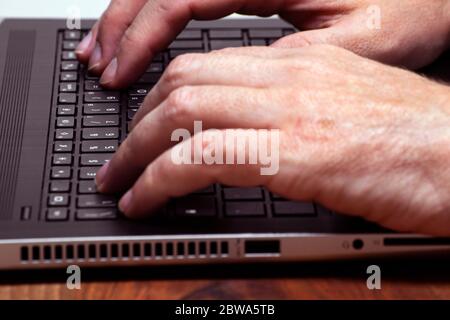 Männliche Hände tippen auf einem Laptop Computer keybord. Business, studyng, intelligente Arbeitskonzepte Stockfoto