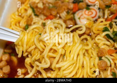 Gekochte Instant-Nudeln mit Gewürzen, getrocknetem Gemüse und gefriergetrocknetem Fleisch. Nahaufnahme Stockfoto