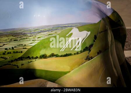 Ein Gebiet der Wiltshire Landschaft, einschließlich eines charakteristischen weißen Pferdes aus Chalkland Downs geschnitten, auf der Flanke eines ornamentalen Löwen für städtische Interesse gemalt Stockfoto