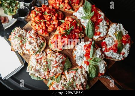 Tomaten- und Basilikumbrote auf dem Brett Stockfoto