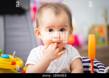 Ein Jahr altes Baby sitzt im Wanderer mit bunten pädagogischen addons. Stockfoto