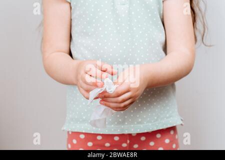 Das Kind wischt ihre Hände nass antibakterielle Tuch. Das Konzept der Handsauberkeit und der Kampf gegen Virusmikroben. Stockfoto