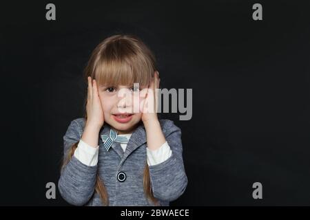 Trauriges Mädchen bedeckt ihre Ohren mit ihren Händen, um nichts zu hören Stockfoto