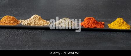 Verschiedene Arten von Gewürzen auf schwarzem Hintergrund Stockfoto