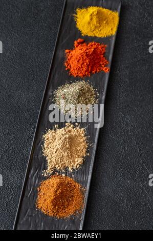 Verschiedene Arten von Gewürzen auf schwarzem Hintergrund Stockfoto