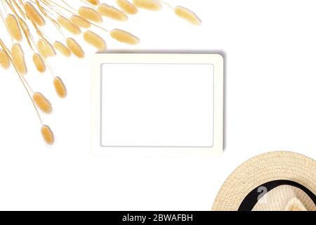 Draufsicht der weißen Rahmen Mockup mit dekorativen getrockneten Gras und Hut auf weißem Hintergrund im Vintage-Stil. Stockfoto