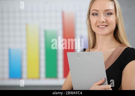 Blonde Geschäftsfrau hält einen Ordner in den Händen auf einem grafischen Hintergrund Stockfoto