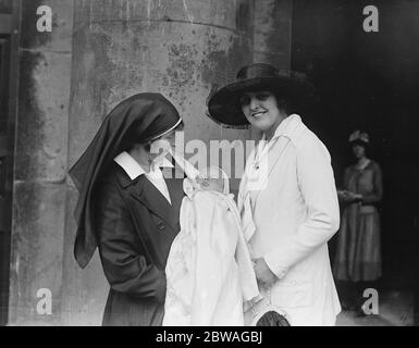 Eine Krankenschwester hält den Sohn des Schauspielers Lupino Lane bei seiner Taufe in St George ' s Church, Bloomsbury, London, während seine stolze Mutter schaut auf. 1920er Jahre Stockfoto