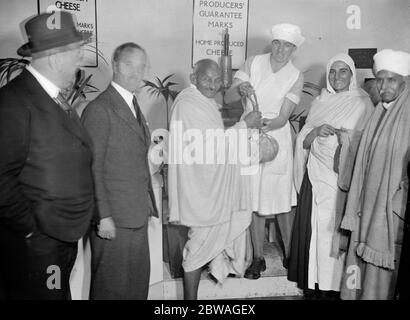 Mahatma Gandhi wird mit zwei Käsesorten aus Ziegenmilch während seines Besuchs auf der Dairy Show in den Royal Agricultural Halls, London vorgestellt. 23. Oktober 1931 Stockfoto