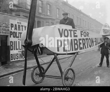 Wahl Zum Meilenende. Wähler, die in einem Flugzeug zum Wahllokal gebracht werden - 1916 Flugzeug ist schwer mit Stimme für Pemberton-Billing Plakat an der Wand hinter liest KEINE Partei politische Abrechnung und Geschäft gebrandmarkt Stockfoto