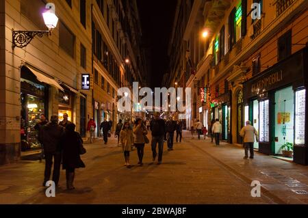 Eine Gasse in Genua mit vielen Fußgängern. Nachtleben in Genua. Stockfoto