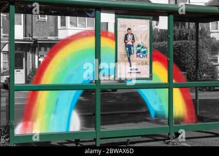 Regenbogen auf Bushaltestelle Tierheim in Bournemouth, Dorset UK im Mai gemalt, um Unterstützung für NHS während Coronavirus Pandemie mit Yellow Buses Poster zu zeigen Stockfoto