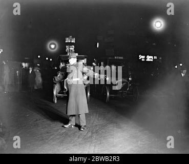 Ein Polizist, der nachts in London den Verkehr lenkt, 12. Dezember 1921 Stockfoto