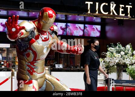 Bangkok, Thailand. Mai 2020. Ein Theaterarbeiter (Einsher) geht an einer Stahl- und Messingstatue des Eisernen Mannes vorbei, während er während der Coronavirus-Krise (COVID-19) eine Gesichtsmaske trägt.Thailand hat bisher 3,082 Coronavirus-Fälle bestätigt, 57 Todesfälle und 2,963 Genesen. Quelle: SOPA Images Limited/Alamy Live News Stockfoto