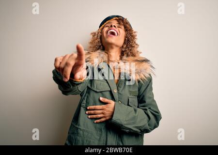 Junge afroamerikanische Skifahrer Frau mit lockigen Haaren tragen Schnee Sportbekleidung und Skibrille lachen Sie, Zeigen Finger auf die Kamera mit der Hand ov Stockfoto