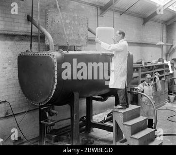 Forschungsarbeiten am National Physical Laboratory, Teddington, um die Pitching-Bewegung von Schiffen auf See zu verringern. Auffüllen des Schmelzbehälters mit Paraffinwachs, das in der Zusammensetzung der Modelle verwendet wird. Stockfoto