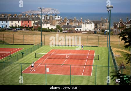 Die Menschen spielen Tennis im North Berwick Tennis Club, da die Menschen Familie und Freunde im Freien treffen und wieder Sport wie Golf und Tennis spielen können, da Schottland in Phase eins des Plans der schottischen Regierung geht, die Sperre schrittweise zu heben. Stockfoto