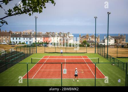 Die Menschen spielen Tennis im North Berwick Tennis Club, da die Menschen Familie und Freunde im Freien treffen und wieder Sport wie Golf und Tennis spielen können, da Schottland in Phase eins des Plans der schottischen Regierung geht, die Sperre schrittweise zu heben. Stockfoto