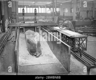 Am National Physical Laboratory , Teddington . Der neue Marine-Test Tank , 678 ft lang , 20 ft breit und Tiefe des Wassers von 9 ft . Modell Abschleppwagen, die Modell Schiffsrümpfen bis zu Geschwindigkeiten von mehr als 30 ft pro Sekunde schleppen kann. Es wird elektrisch mit Strom durch Oberleitungen in Foto gesehen versorgt angetrieben. Vorrichtung zum Testen Propeller . Der Propeller wird auf einer Welle vor dem Körper gehalten und vollständige Aufzeichnungen über sein Verhalten gemacht, so dass durch die Prüfung mehrere die beste Schraube für jedes bestimmte Schiff gefunden werden kann. 14. November 1932 Stockfoto