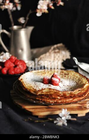 Dünne Crepes, Pfannkuchen oder Blinis auf Schiefer isoliert auf schwarzem Hintergrund, leckeres Frühstück Stockfoto