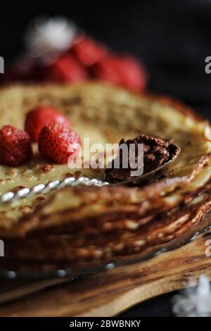 Dünne Crepes, Pfannkuchen oder Blinis auf Schiefer isoliert auf schwarzem Hintergrund, leckeres Frühstück Stockfoto