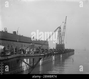 Um deutsche Kriegsschiffe bei Scapa Flow zu retten, übergab deutsche U-Boot-Dock, umgebaut für Hebezwecke, Segel aus Queenborough für den Einsatzort der Hebeseite des Docks, mit den Rädern, die für Bergungsarbeiten montiert wurden 23 April 1924 Stockfoto