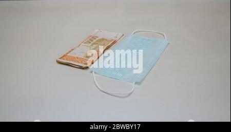 Chirurgische Maske mit großer Geldsumme, die eine Preiserhöhung aufgrund einer höheren Nachfrage darstellt Stockfoto