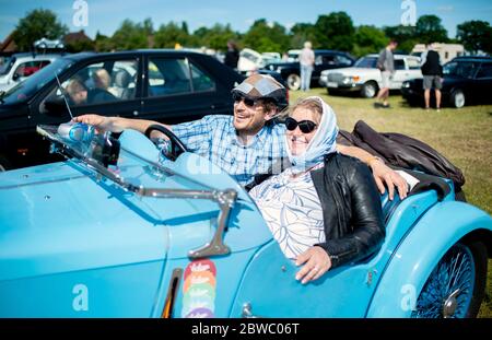 Hude, Deutschland. Mai 2020. Gustav-Eugen Frerichs (l.), Mitglied des Motor-Sport-Clubs Oldenburg e.V. und Mitinitiator der Veranstaltung, sitzt mit seiner Frau Tanja im Oldtimer auf dem Gelände eines Drive-in-Kinos im Stadtteil Wüsting. Mehrere hundert Personen in ihren Oldtimern, Youngtimern und amerikanischen Oldtimern nahmen an der Veranstaltung im Oldenburger Kreis Teil. Die Oldtimer-Fans schauten sich den Film "Le Mans 66 - gegen alle Widrigkeiten" in rund 200 historischen Autos an. Kredit: Hauke-Christian Dittrich/dpa/Alamy Live News Stockfoto
