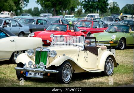 Hude, Deutschland. Mai 2020. Ralf und Ulrike sitzen in ihrem 1953-Jahr-MG TD auf dem Gelände eines Drive-in-Kinos im Stadtteil Wüsting. Mehrere hundert Menschen haben an der Veranstaltung im Landkreis Oldenburg mit ihren Oldtimern, jungen und amerikanischen Oldtimern teilgenommen. Die Oldtimer-Fans schauten sich den Film "Le Mans 66 - gegen alle Widrigkeiten" in rund 200 historischen Fahrzeugen an. Kredit: Hauke-Christian Dittrich/dpa/Alamy Live News Stockfoto