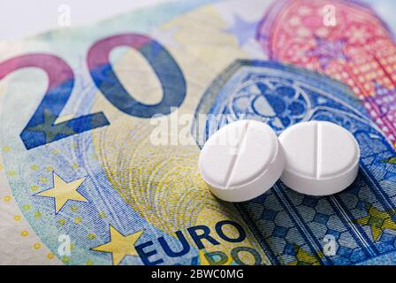 Zwei generische weiße Tabletten auf einem 20 Euro-Schein in einem Konzept der Zahlung von medizinischen Gebühren und Kosten für die Gesundheitsversorgung Stockfoto