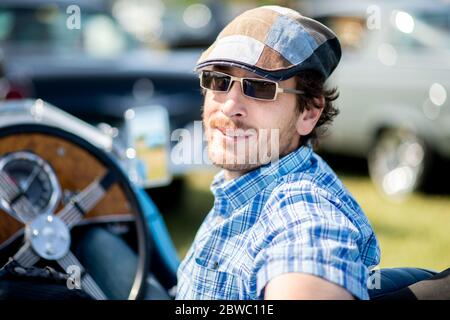 Hude, Deutschland. Mai 2020. Gustav-Eugen Frerichs, Mitglied des Motor-Sport-Clubs Oldenburg e.V. und Mitinitiator der Veranstaltung, sitzt im Oldtimer auf dem Gelände eines Drive-in-Kinos im Stadtteil Wüsting. Mehrere hundert Personen in ihren Oldtimern, Youngtimern und amerikanischen Oldtimern nahmen an der Veranstaltung im Oldenburger Kreis Teil. Die Oldtimer-Fans schauten sich den Film "Le Mans 66 - gegen alle Widrigkeiten" in rund 200 historischen Autos an. Kredit: Hauke-Christian Dittrich/dpa/Alamy Live News Stockfoto