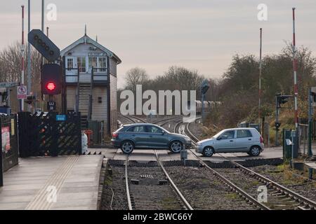 Autos, die über den Bahnübergang auf der Eisenbahn in Ulceby, Lincolnshire fahren, kurz nachdem ein Zug vorbeigefahren war Stockfoto