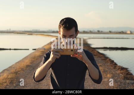 Mann, der ein Foto bei Sonnenuntergang macht Stockfoto