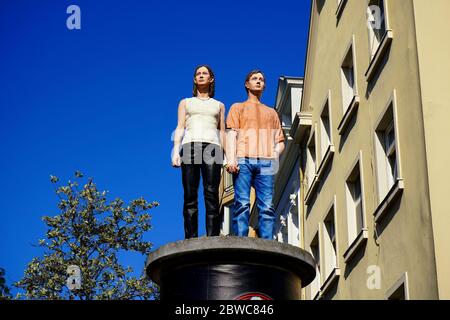 Sogenannte "Säulenheilige" (lebensechte Skulpturen auf Werbungssäulen). Künstler: Christoph Pöggeler. Lage: Düsseldorf, Burgplatz, Altstadt. Stockfoto