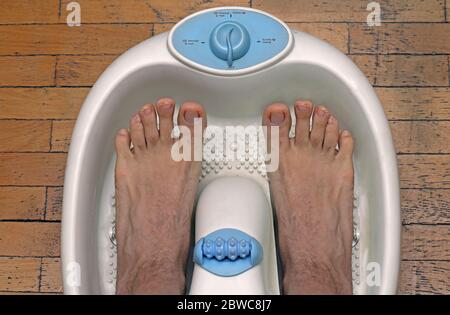 Männliche Füße in Kunststoff Pediküre Badewanne immer bereit für die Behandlung Stockfoto
