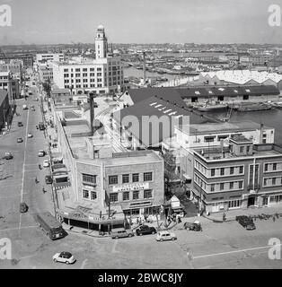 Ende der 1950er Jahre, historische, Luftaufnahme der Innenstadt von Tokio aus dieser Zeit, zeigt die Autos und Transport und niedrigen Gebäuden. Auf dem Bild sehen Sie das Restaurant Yokohama, das Japan Travel Bureau und Ocean Souvenirs. Man sieht auch die Straßenlage der Stadt und in der Ferne den Fluss und den Hafen. Stockfoto