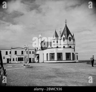 1950er Jahre, historisch, Außenansicht des John o'Groats House Hotels, Canisbay, Caithness, Schottland, Großbritannien, zeigt die markante Form des Gebäudes, Auf dem Parkplatz mit Türmchen und Schottergrund befindet sich eine Tankstelle.das ikonische achteckige Haus wurde 1875 in der Nähe oder auf dem Gelände des Holländers Jan de Groot gebaut, von dem der Standort seinen Namen hat. Wer in früheren Zeiten eine Fähre zur Insel Orkney fuhr und eine Münze, die als "Leistengegend" bekannt wurde, in Rechnung stellte. Stockfoto