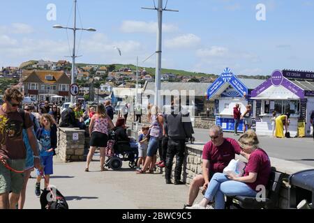 West Bay, Dorset / England - Mai 31,2020: Die Leute genießen den sonnigen Tag am Fish and Chips Stand in West Bay, Dorset. Stockfoto