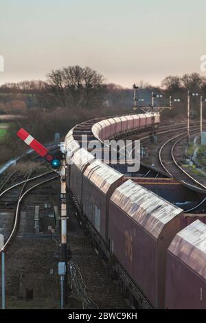 DB Cargo Merry fahren um den Kohlefrachtzug, der die mechanischen Bahnsignale in Barnetby, Lincs passiert. Das obere Quadrantsignal ist 'aus'. Stockfoto