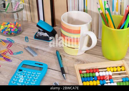 Auf der Tischplatte befinden sich hölzerne Abakus und ein elektronischer blauer Rechner. Stockfoto