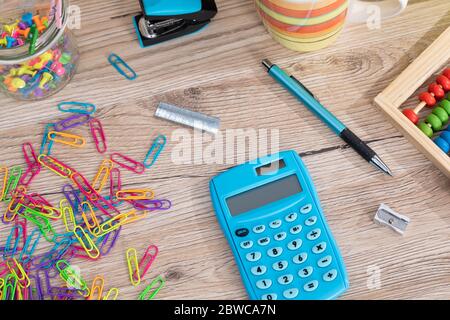 Auf der Tischplatte befinden sich hölzerne Abakus und ein elektronischer blauer Rechner. Stockfoto