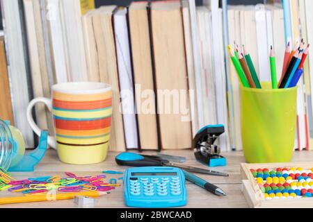 Auf der Tischplatte befinden sich hölzerne Abakus und ein elektronischer blauer Rechner. Stockfoto