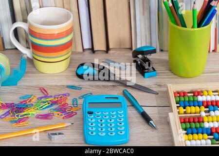 Auf der Tischplatte befinden sich hölzerne Abakus und ein elektronischer blauer Rechner. Stockfoto