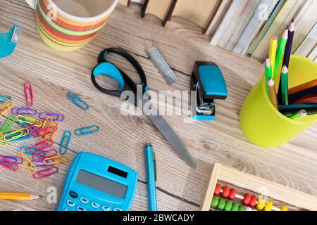 Auf der Tischplatte befinden sich hölzerne Abakus und ein elektronischer blauer Rechner. Stockfoto