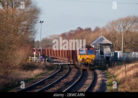 DB Güterbahn der Baureihe 66 Lokomotive 66099 vorbei an der Elsham Signalbox mit einem Güterzug mit Eisenerz Stockfoto