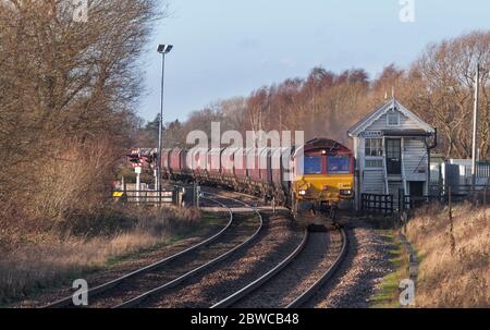 DB Cargo Rail Baureihe 66 Lokomotive 66104 Passieren der Holz Elsham Signalbox mit einem leeren fröhlichen gehen rund Kohle Zug Stockfoto