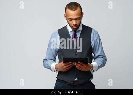 Professioneller afroamerikanischer Geschäftsmann, der Tablet-pc hält Stockfoto