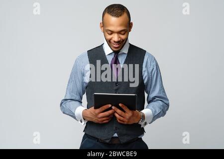 Professioneller afroamerikanischer Geschäftsmann, der Tablet-pc hält Stockfoto