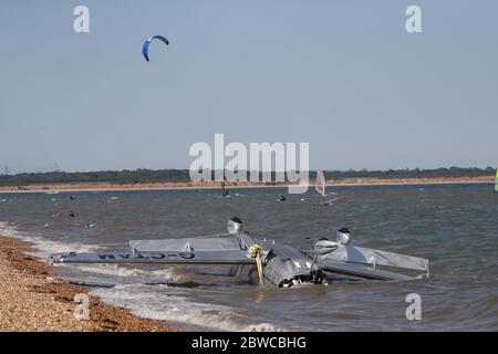 Die Trümmer leichter Flugzeuge wuschen am Strand, nachdem sie in das Meer nahe Calshot Spit stürzten. Zwei Menschen wurden aus dem Flugzeug gerettet. Stockfoto